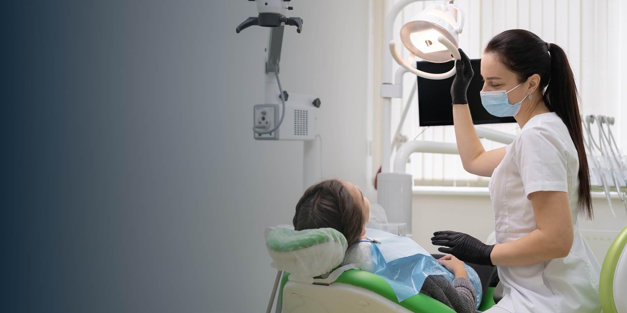 hygienist moving overhead lamp with patient in chair