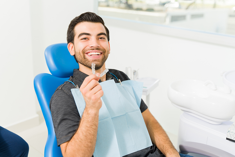 young man with aligner in dentist chair