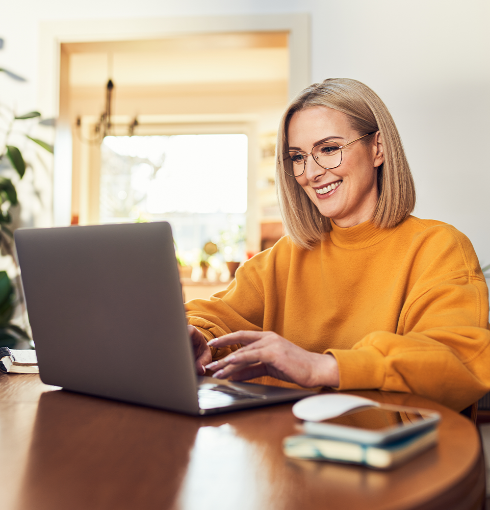 woman smiling looking at her computer